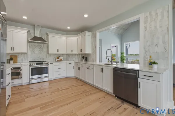 a dining hall with stainless steel appliances granite countertop a refrigerator a sink a dining table and chairs with wooden floor