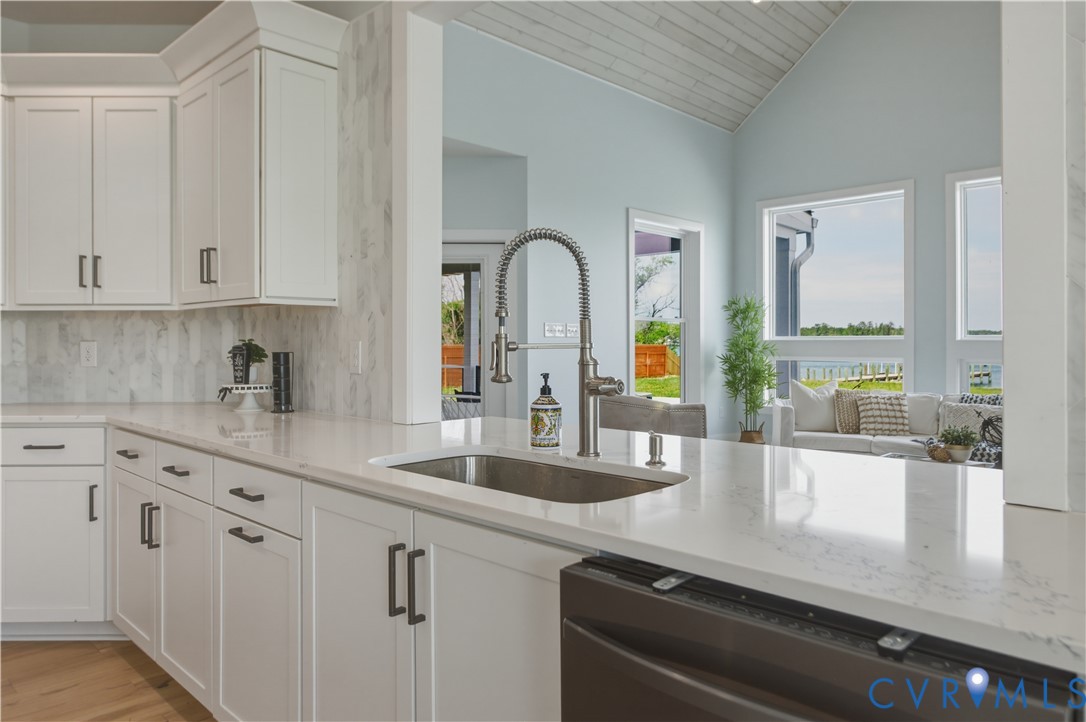 1355 Cowart Road Lottsburg, VA 22511 - Photo 32 of 65 a kitchen with stainless steel appliances granite countertop a sink a stove and white cabinets with wooden floor