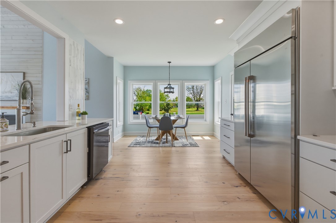 1355 Cowart Road Lottsburg, VA 22511 - Photo 34 of 65 a dining hall with stainless steel appliances granite countertop a refrigerator a sink a dining table and chairs with wooden floor