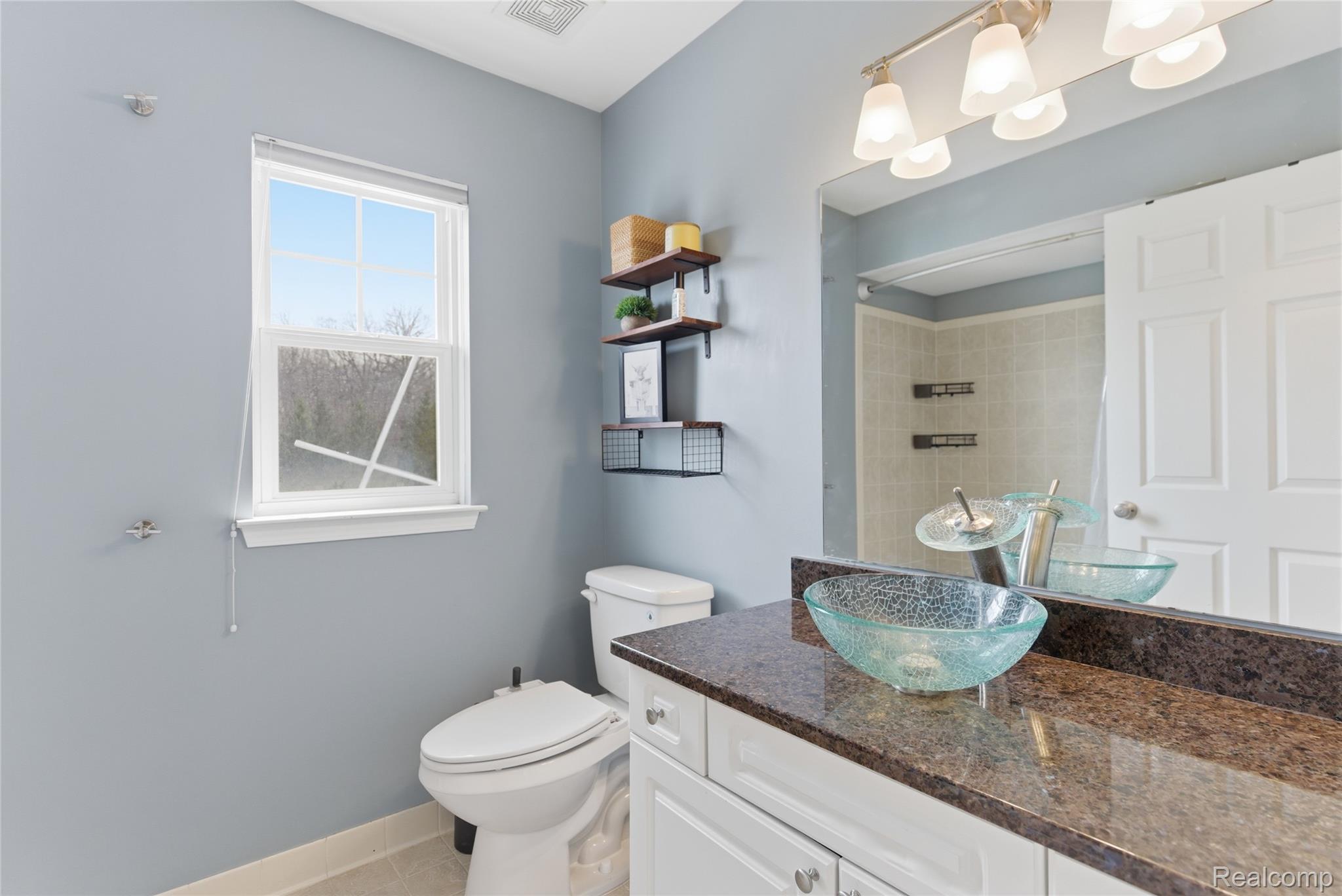 3402 Tremonte Circle Rochester, MI 48306 - Photo 17 of 37 Bathroom featuring vanity, a shower, and light tile patterned floors