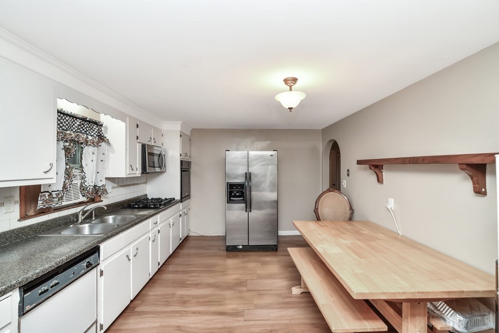 106 Haynes Road Stoughton, MA 02072 - Photo 2 of 34 a large white kitchen with a sink and stainless steel appliances