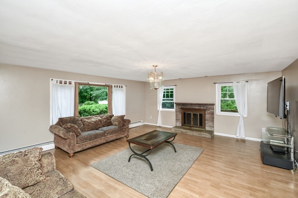 106 Haynes Road Stoughton, MA 02072 - Photo 7 of 34 a living room with furniture flat screen tv and a fireplace
