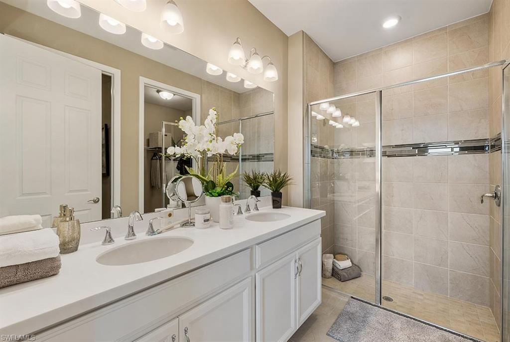 922 Enbrook Loop, Unit 46 Naples, FL 34114 - Photo 13 of 31 a bathroom with a double vanity sink mirror and shower