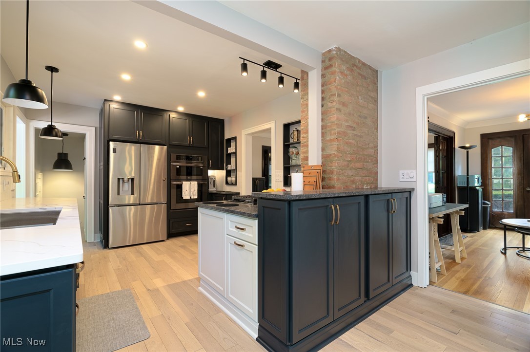 2624 Lee Road Cleveland, OH 44118 - Photo 14 of 50 Kitchen with light hardwood flooring, granite and quartz countertops, track, pendant and recessed lighting. Cabinets are dark charcoal that hint of blue when extra lighting occurs