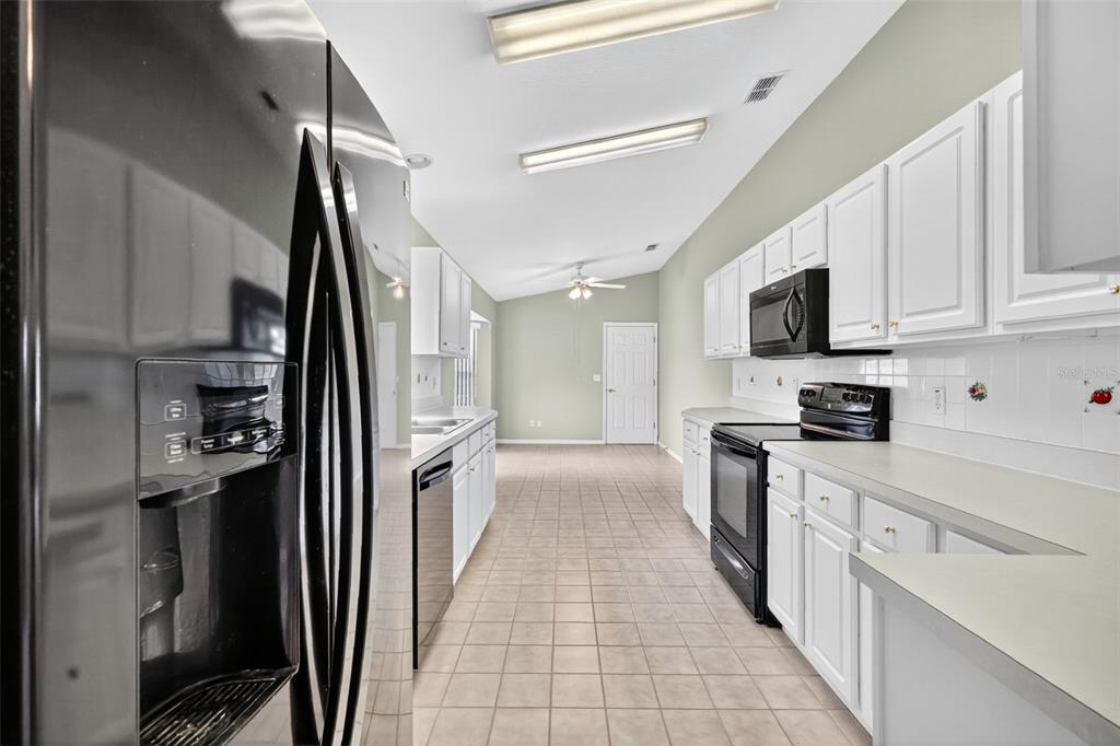 11353 Southwest 138th Lane Dunnellon, FL 34432 - Photo 15 of 33 a kitchen with white cabinets and stainless steel appliances