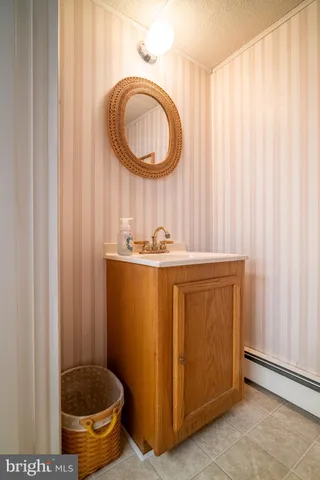 a bathroom with a granite countertop sink and a mirror
