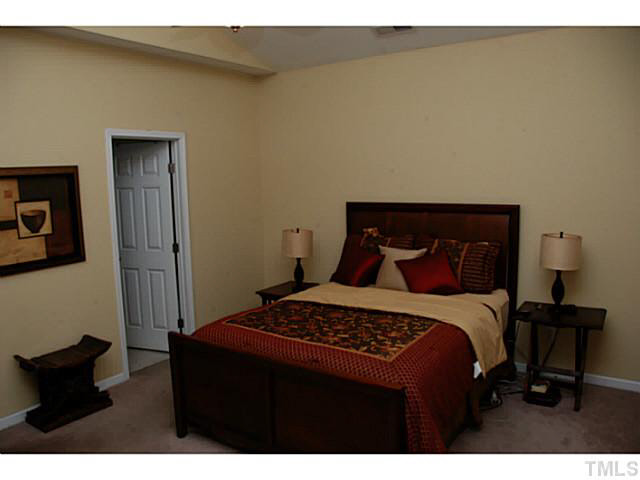 3102 Rendezvous Drive Raleigh, NC 27610 - Photo 14 of 24 a bedroom with a bed and a lamp on dresser