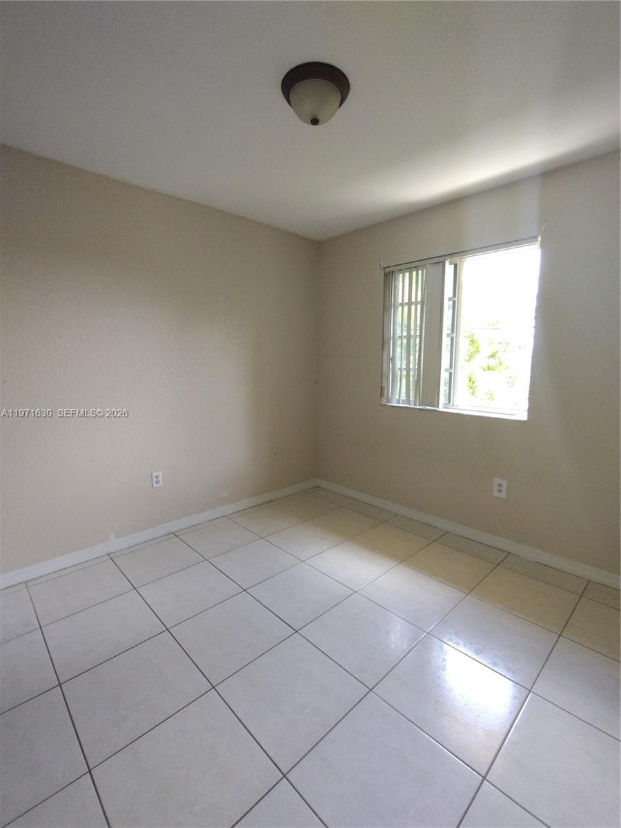 6756 Northwest 182nd Street, Unit 101 Hialeah, FL 33015 - Photo 12 of 29 a view of an empty room with a window