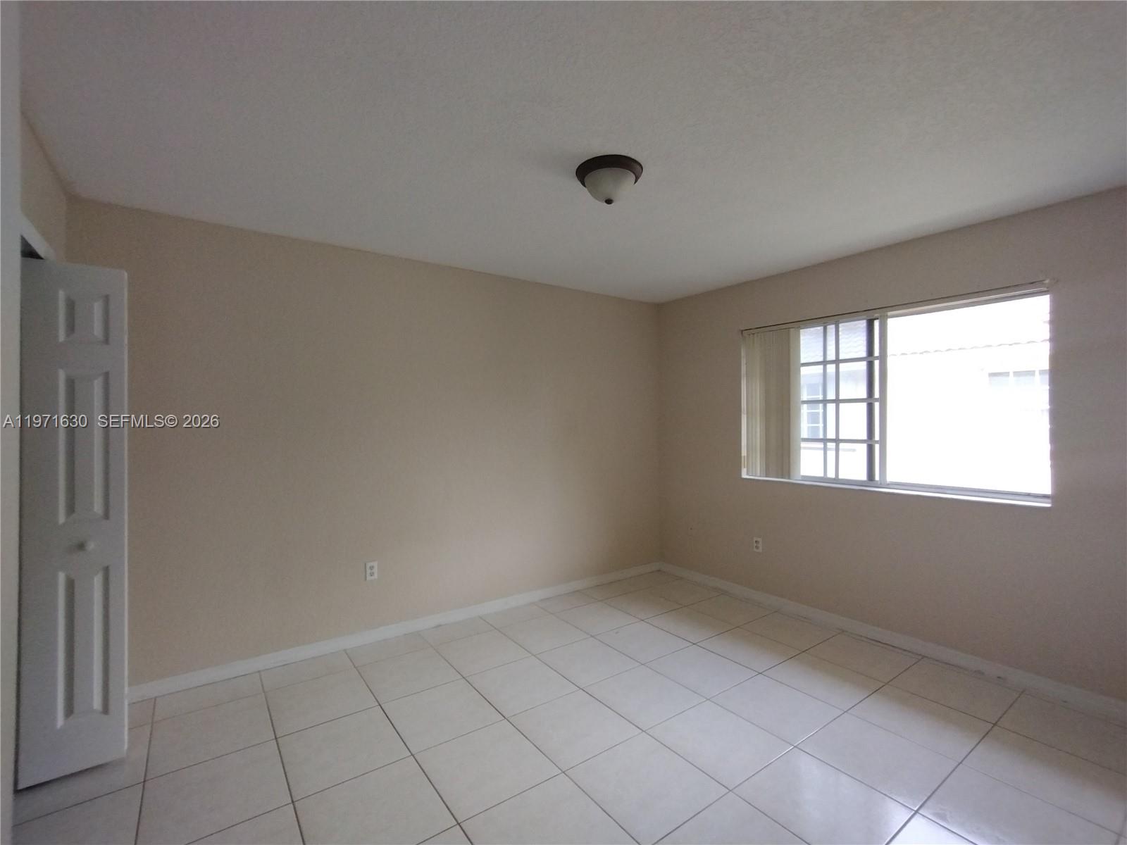 6756 Northwest 182nd Street, Unit 101 Hialeah, FL 33015 - Photo 15 of 29 a view of an empty room with a window