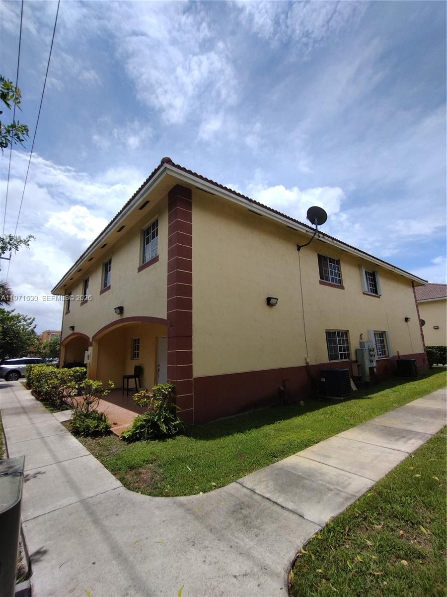 6756 Northwest 182nd Street, Unit 101 Hialeah, FL 33015 - Photo 2 of 29 a front view of house with yard and green space