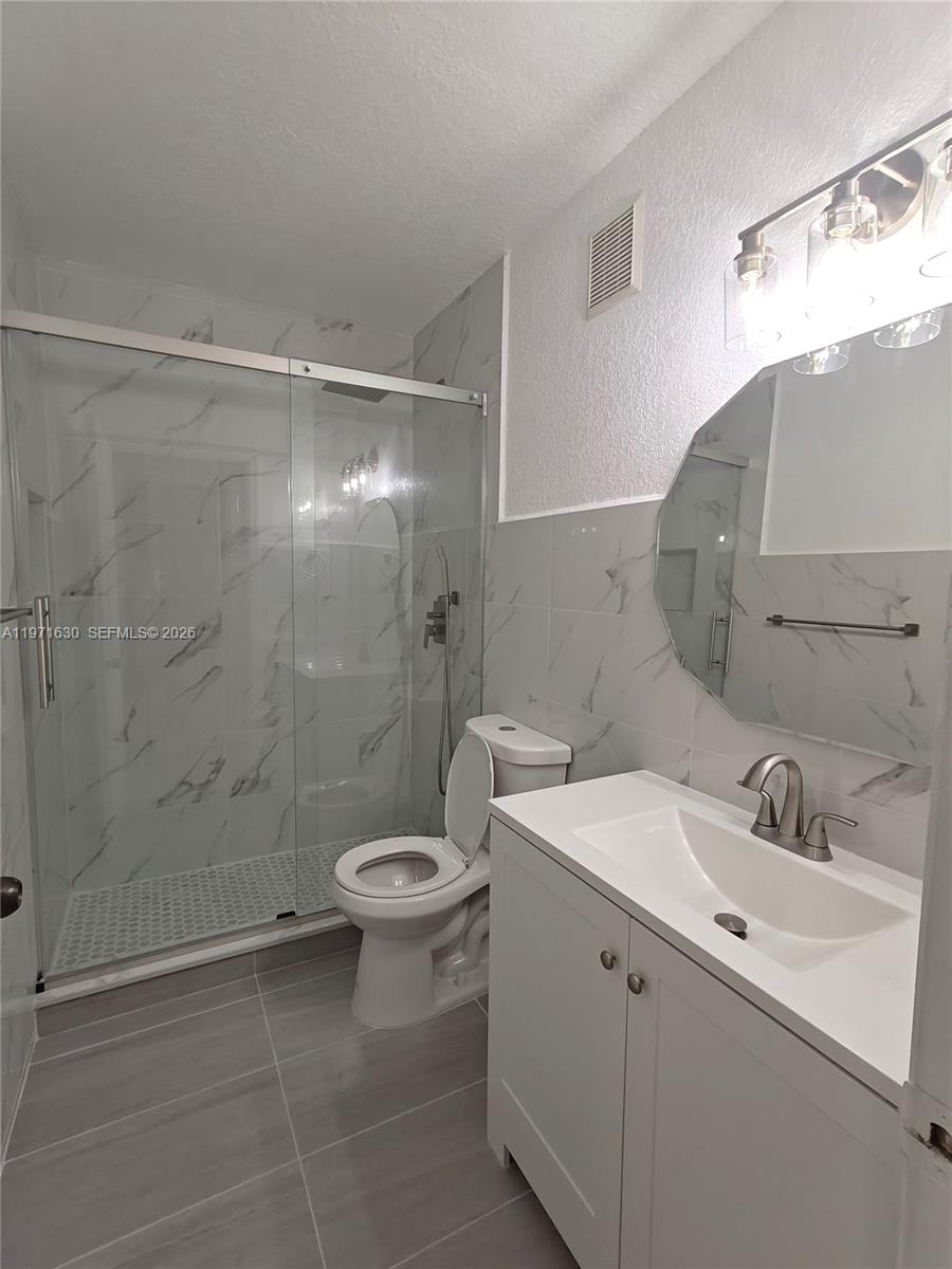 6756 Northwest 182nd Street, Unit 101 Hialeah, FL 33015 - Photo 22 of 29 a bathroom with a sink toilet and shower