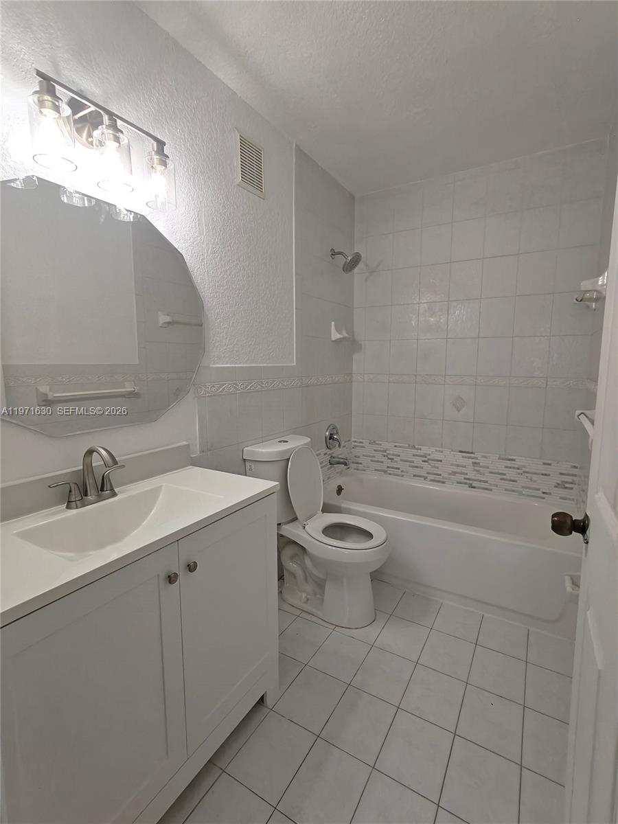 6756 Northwest 182nd Street, Unit 101 Hialeah, FL 33015 - Photo 25 of 29 a bathroom with a sink a toilet and shower