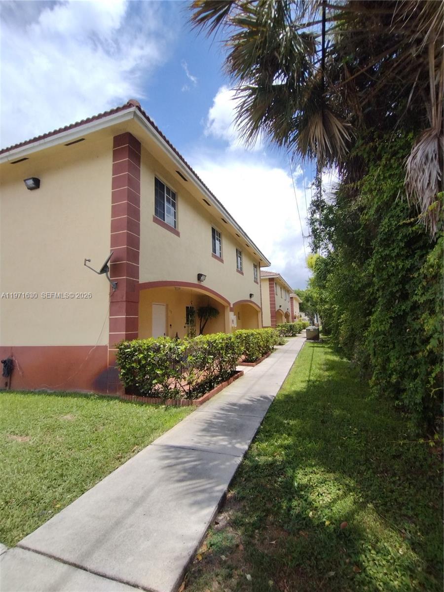 6756 Northwest 182nd Street, Unit 101 Hialeah, FL 33015 - Photo 4 of 29 a front view of house with yard and green space