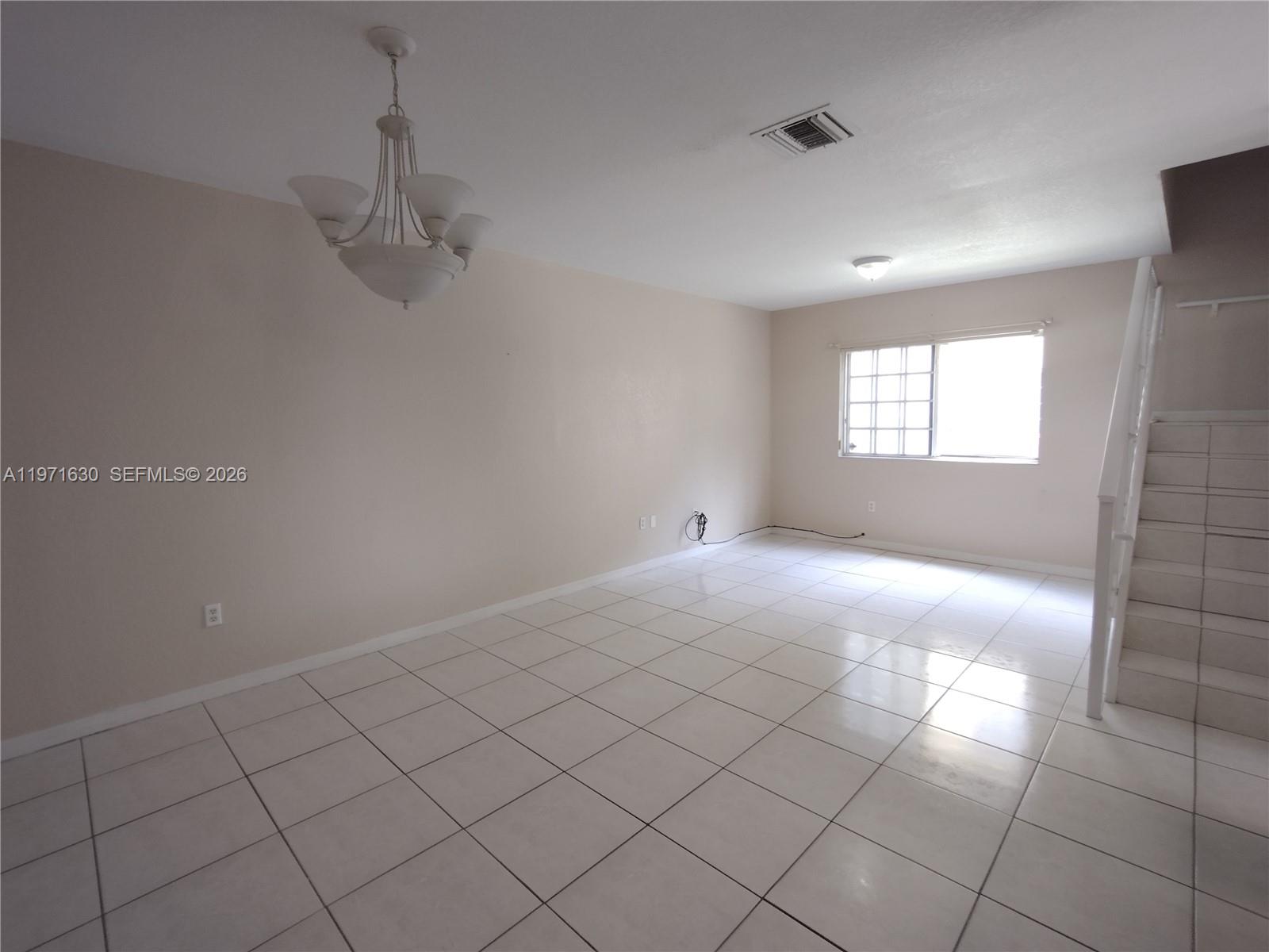 6756 Northwest 182nd Street, Unit 101 Hialeah, FL 33015 - Photo 8 of 29 an empty room with windows and fan