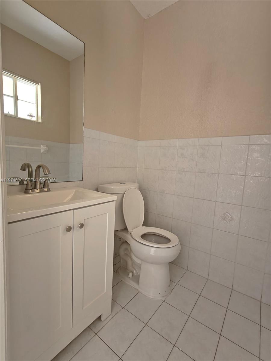 6756 Northwest 182nd Street, Unit 101 Hialeah, FL 33015 - Photo 10 of 29 a bathroom with a toilet sink and mirror