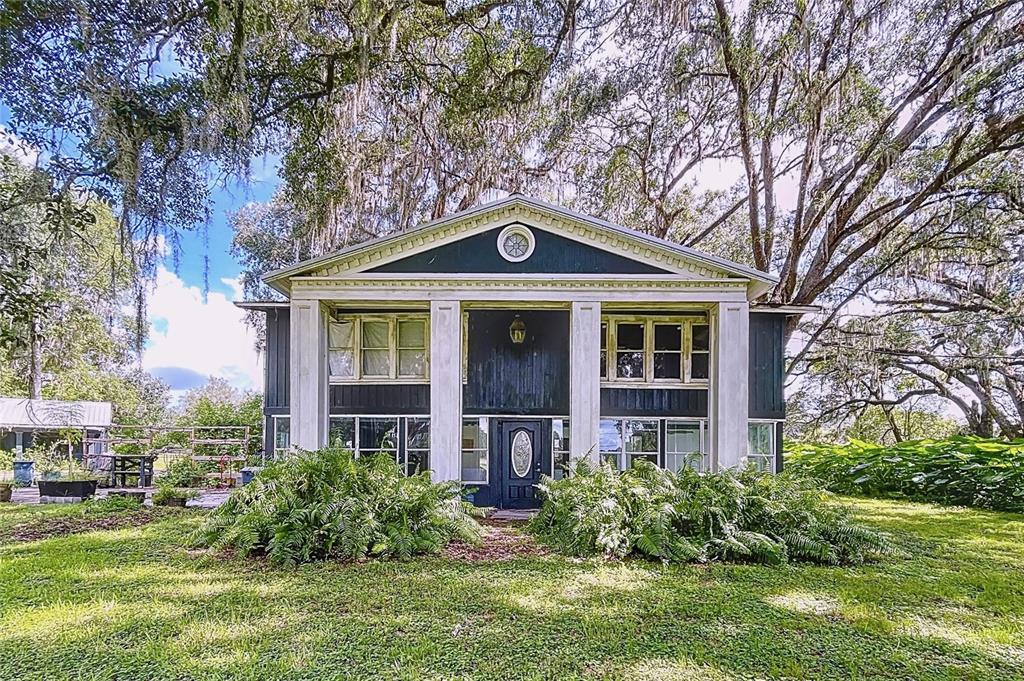 a front view of a house with yard and green space