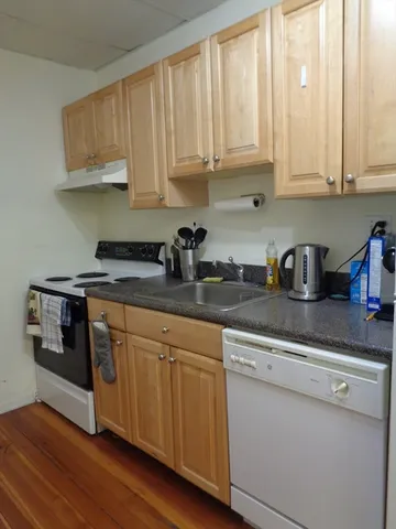 a kitchen with stainless steel appliances granite countertop a sink and cabinets with wooden floor