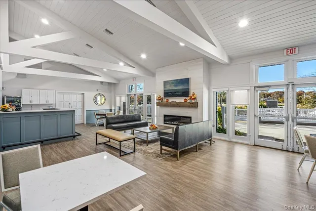 a living room with furniture a flat screen tv and wooden floor