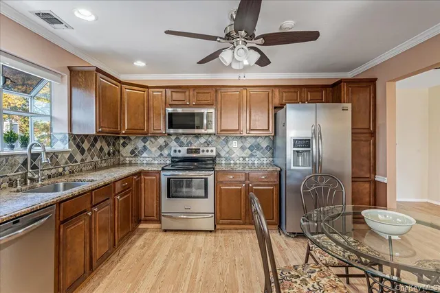 a kitchen with stainless steel appliances granite countertop a sink refrigerator stove and microwave