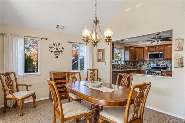 a view of a dining room with furniture and a chandelier