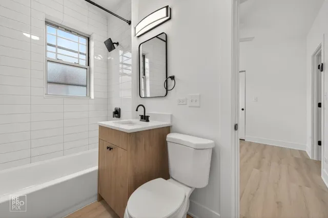 a bathroom with a toilet a sink a mirror and bathtub