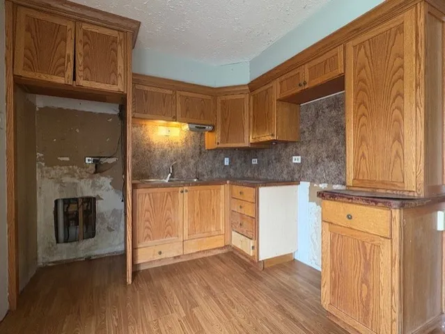 a kitchen with granite countertop wooden floors and stainless steel appliances