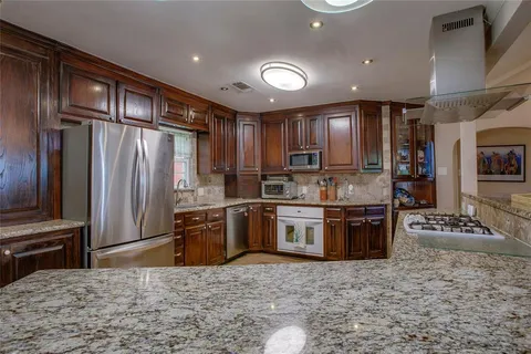 a kitchen with granite countertop stainless steel appliances and wooden cabinets