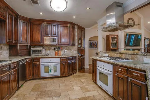 a kitchen with stainless steel appliances granite countertop a stove sink and cabinets