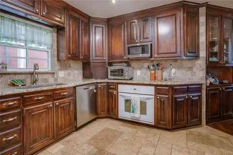a kitchen with stainless steel appliances granite countertop wooden cabinets a sink and dishwasher