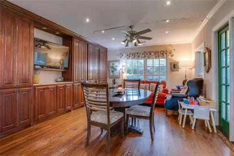 a dining room with furniture a chandelier and wooden floor
