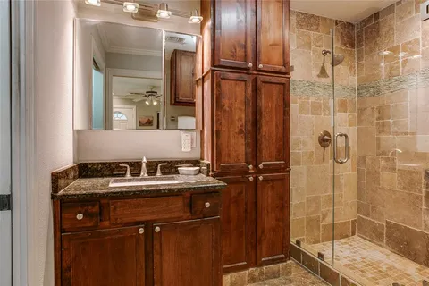 a bathroom with a sink vanity granite shower and a mirror