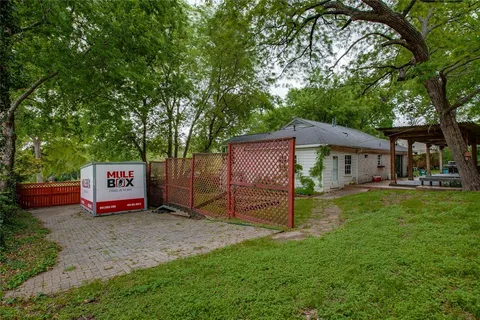 a view of a house with backyard and a tree