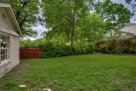 a front view of a house with a garden and yard