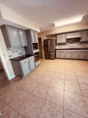 a large kitchen with cabinets and steel stainless steel appliances