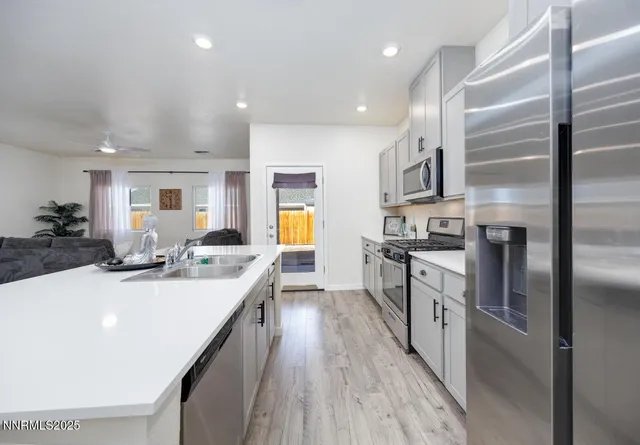 a kitchen with stainless steel appliances granite countertop a sink stove and refrigerator