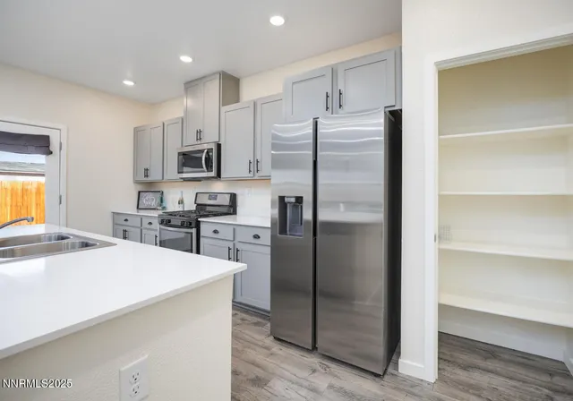 a kitchen with stainless steel appliances a refrigerator sink and microwave