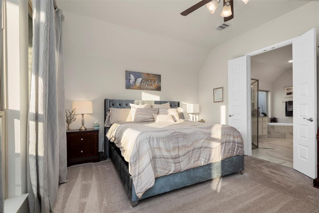 28196 Knight Peak Drive Spring, TX 77386 - Photo 12 of 31 a bedroom with a bed and a chandelier