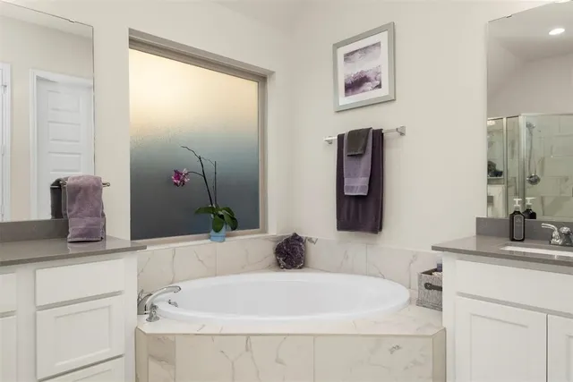 a bathroom with a tub sink and mirror