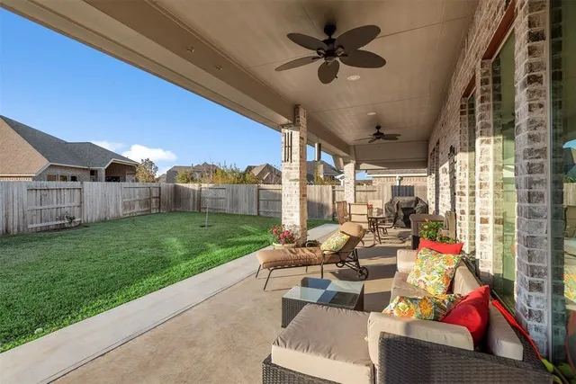 a living room with patio furniture and a garden