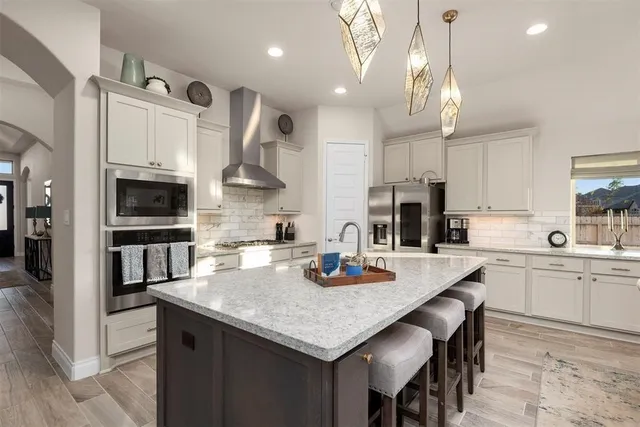 a kitchen with granite countertop a table chairs microwave and cabinets