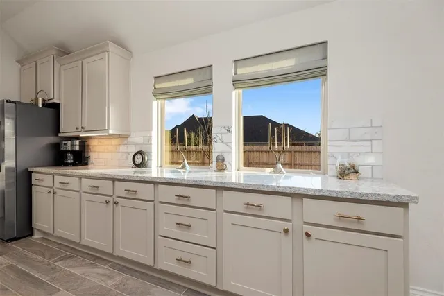 a kitchen with granite countertop white cabinets and white appliances