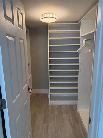 a view of walk in closet with empty racks