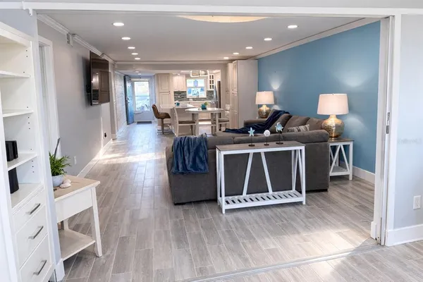 a living room with stainless steel appliances furniture a rug and a view