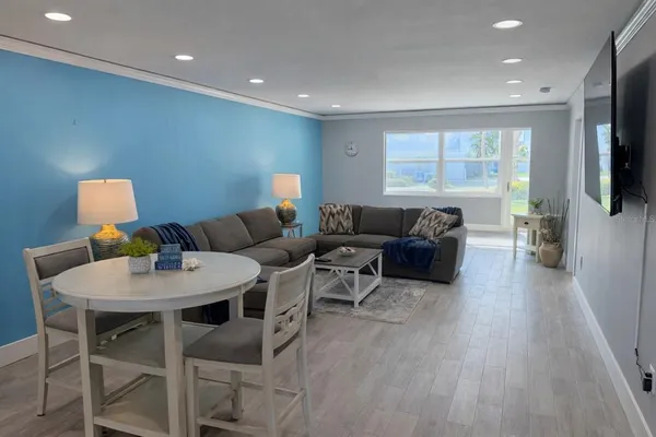 a living room with furniture a flat screen tv and a large window