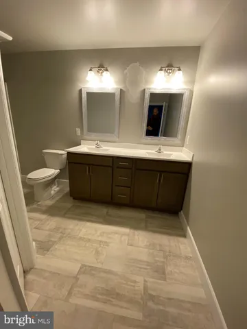 a bathroom with a sink a toilet a mirror and shower