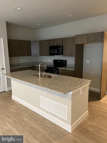 a kitchen with stainless steel appliances granite countertop a sink stove and microwave