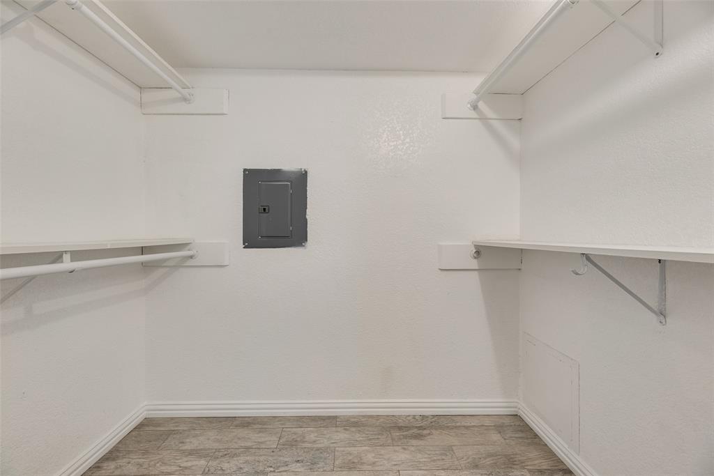 5109 Cedar Springs Road, Unit 105 Dallas, TX 75235 - Photo 12 of 16 White-painted interior space featuring upper and lower shelving with hanging rods