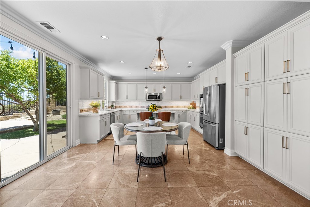 19628 Mathilde Lane Saugus, CA 91350 - Photo 11 of 59 a kitchen with a refrigerator a sink dishwasher a stove and a dining table with garden view