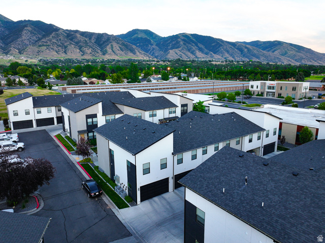 220 Spring Creek Parkway Providence, UT 84332 - Photo 18 of 26 Modern townhome exteriors featuring white and dark gray facades, dark shingle roofing, and integrated garages
