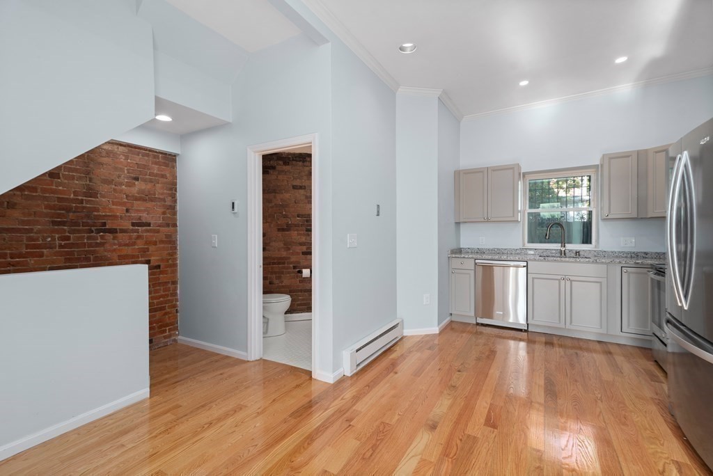 2 Woodbine Street, Unit 1 Boston, MA 02119 - Photo 4 of 20 a kitchen with a refrigerator and a stove top oven